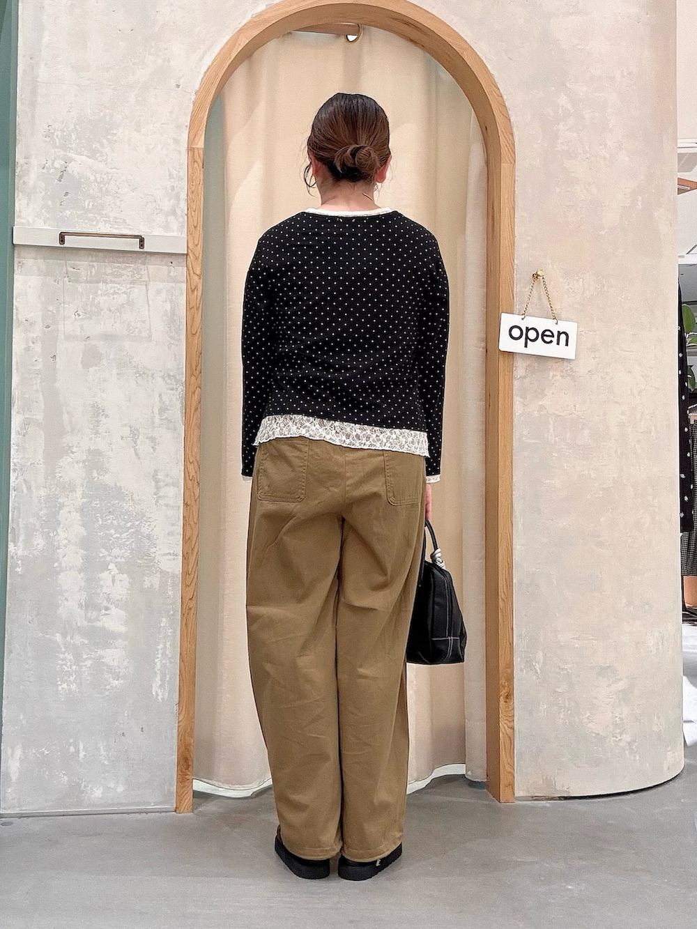 ブラック系のショルダーバッグ、ベージュ系のその他パンツ、ブラック系のカーディガン/ボレロを着用したレディースの秋コーディネートの3枚目の写真