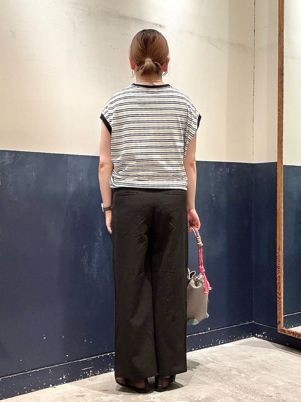 ブラック系のパンプス、グレー系のショルダーバッグ、ブラック系のスラックスを着用したレディースの春コーディネートの3枚目の写真