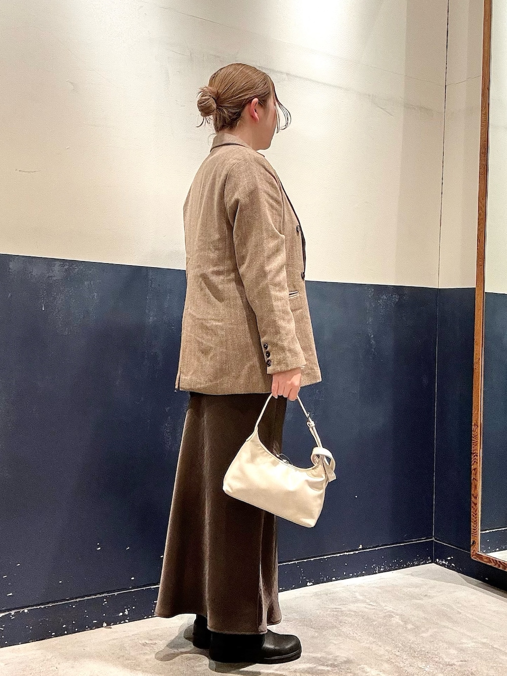 グレー系のショルダーバッグ、グレー系のスカート、ホワイト系のTシャツ/カットソーを着用したレディースの冬コーディネートの2枚目の写真