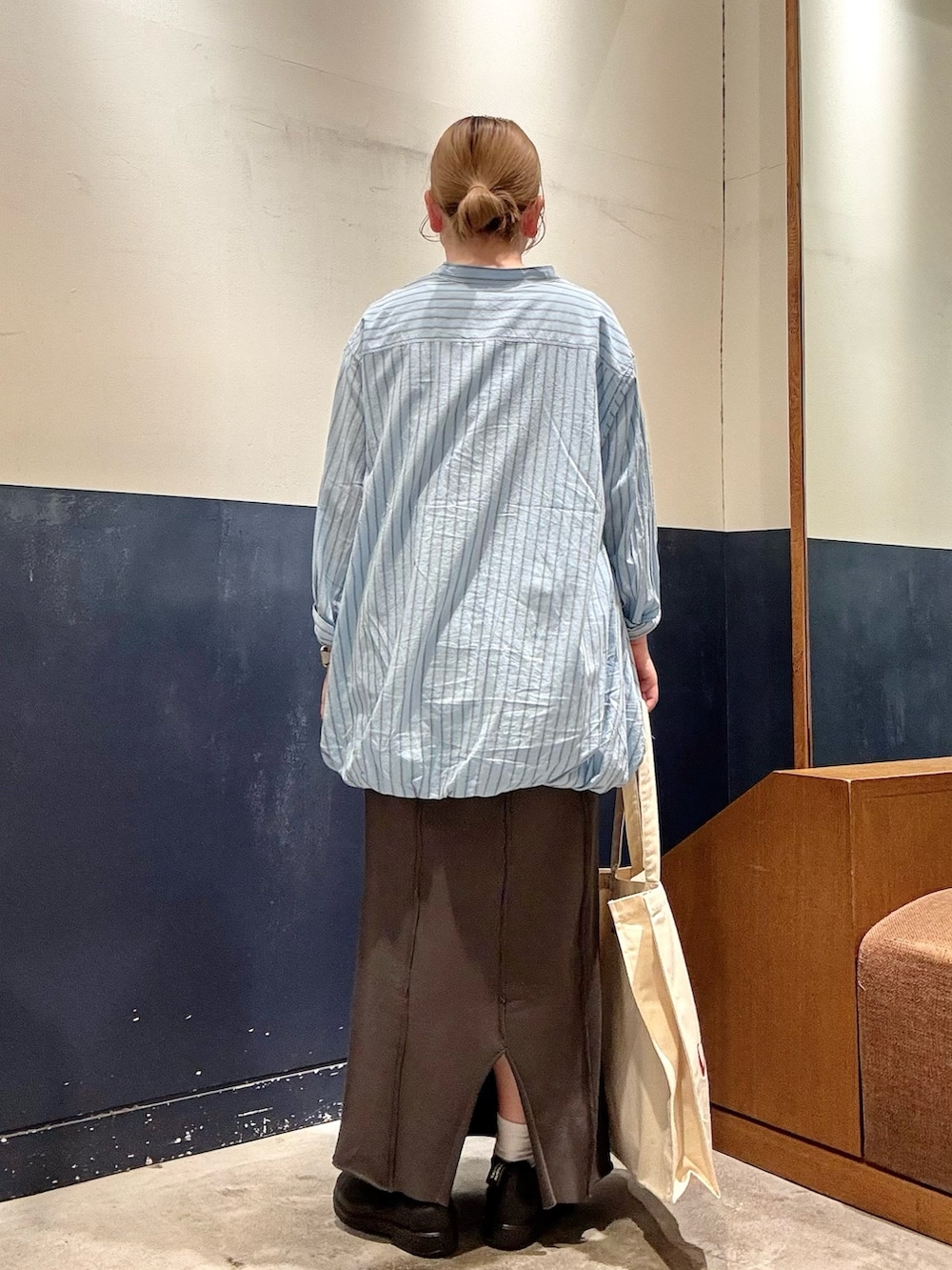 ホワイト系のトートバッグ、グレー系のスカート、ブルー系のシャツ/ブラウスを着用したレディースの春コーディネートの3枚目の写真