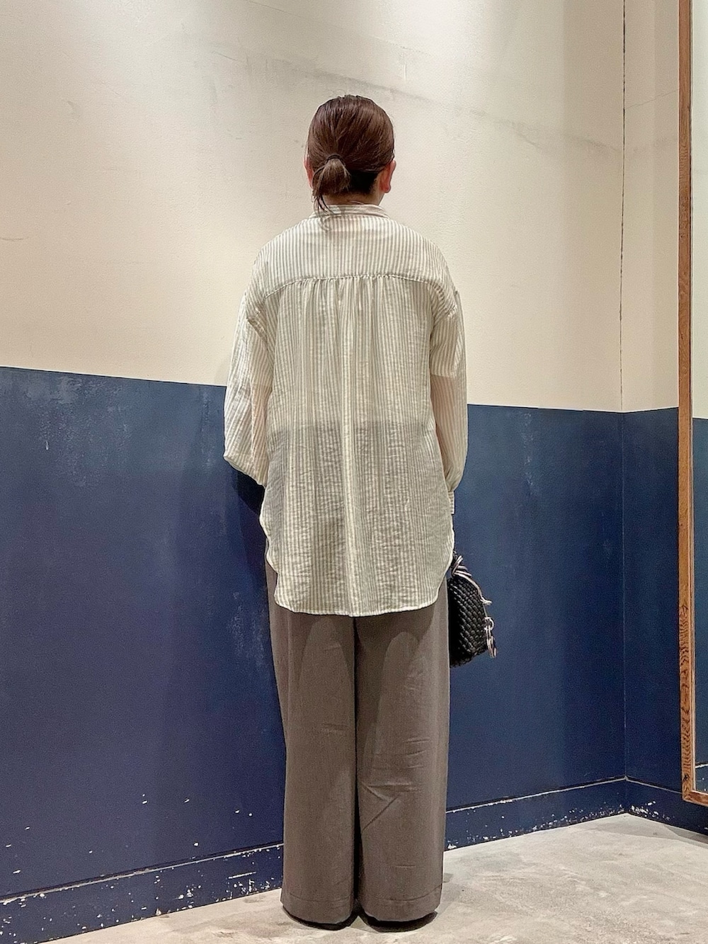 グレー系のデニムパンツ、ブラック系のショルダーバッグ、ブラック系のパンプスを着用したレディースの夏コーディネートの3枚目の写真