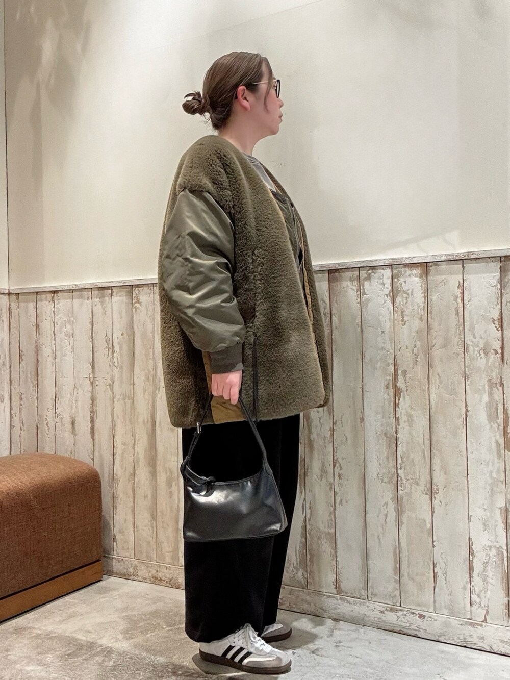 グリーン系のブルゾン、グレー系のスウェット、ブラック系のショルダーバッグを着用したレディースの冬コーディネートの2枚目の写真