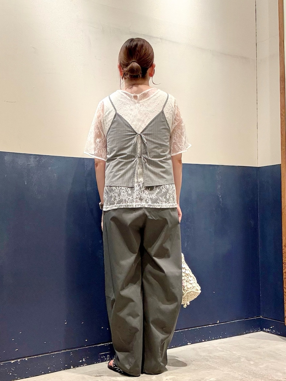 グレー系のその他パンツ、ブラック系のサンダル、ホワイト系のショルダーバッグを着用したレディースの夏コーディネートの3枚目の写真