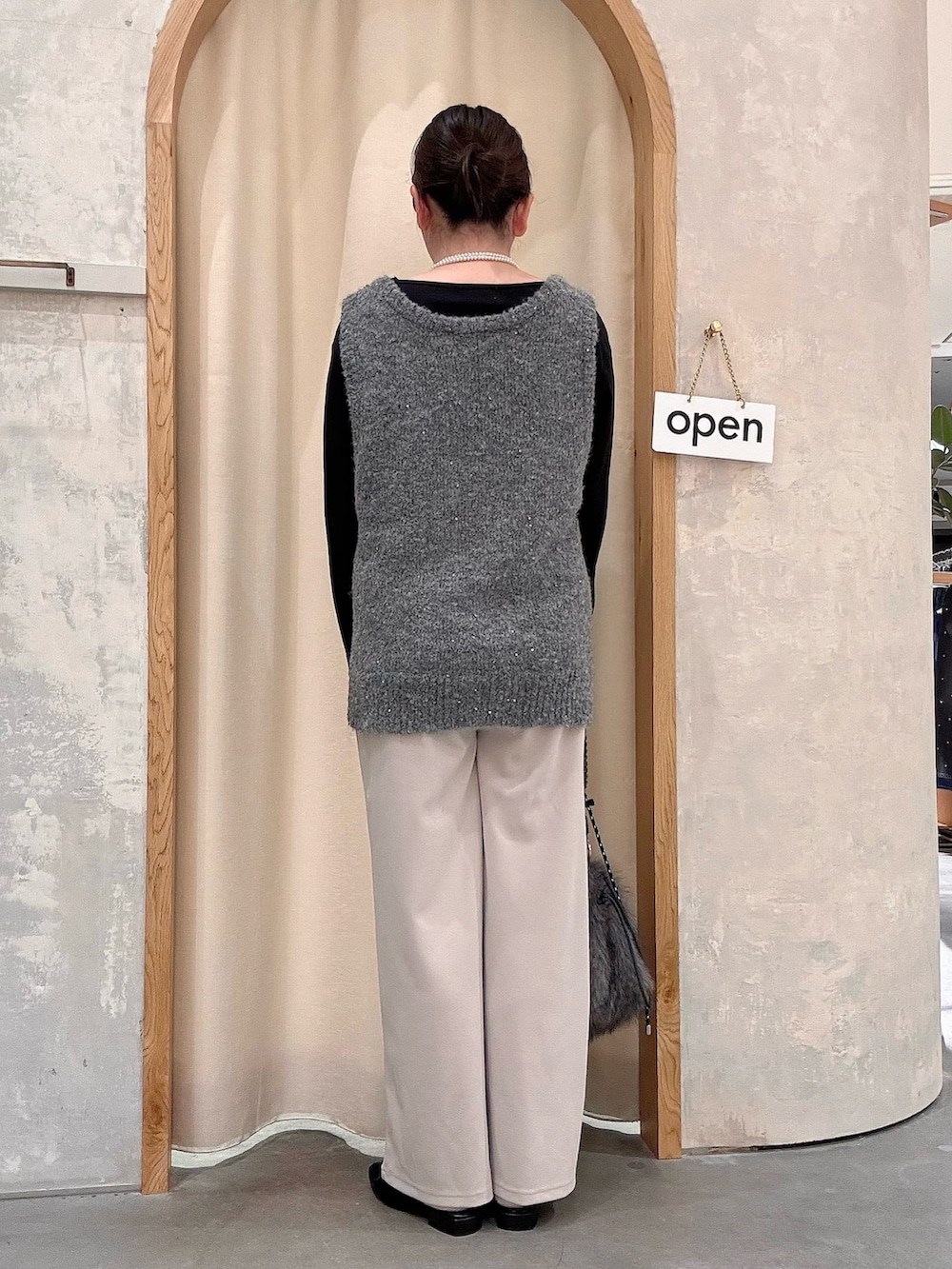 グレー系のトートバッグ、ブラック系のパンプス、ブラック系のTシャツ/カットソーを着用したレディースの秋コーディネートの3枚目の写真