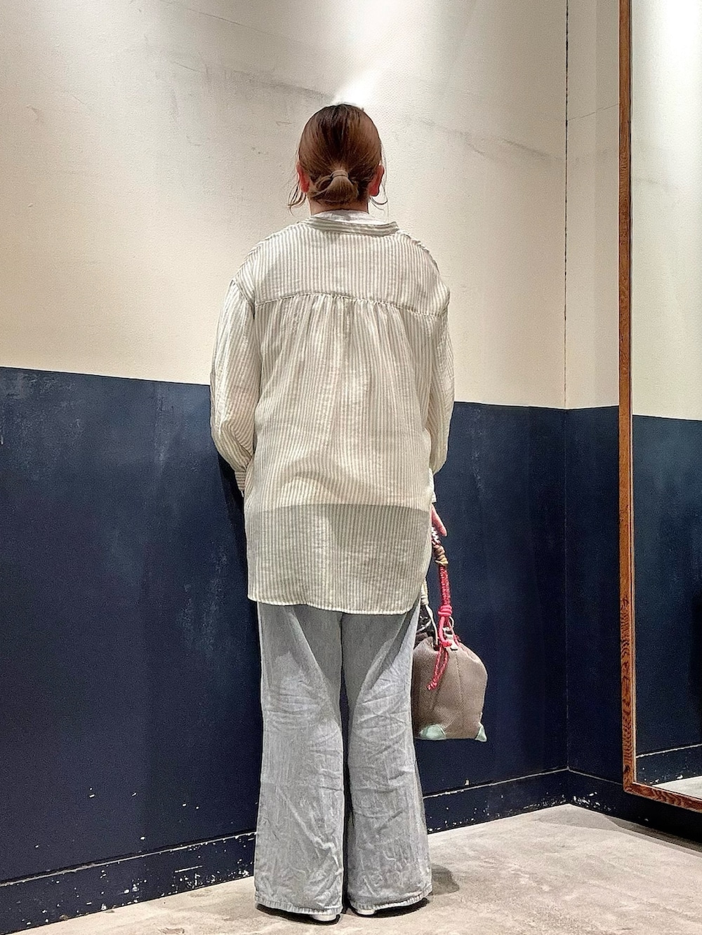 グレー系のショルダーバッグ、ブルー系のデニムパンツ、グリーン系のシャツ/ブラウスを着用したレディースの夏コーディネートの3枚目の写真