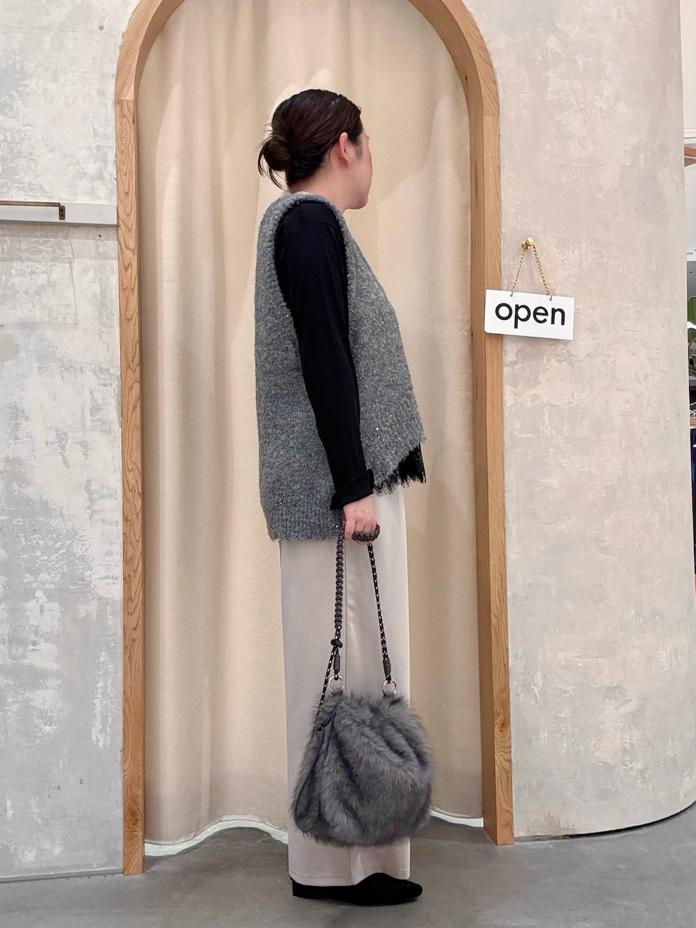 グレー系のトートバッグ、ブラック系のパンプス、ブラック系のTシャツ/カットソーを着用したレディースの秋コーディネートの2枚目の写真