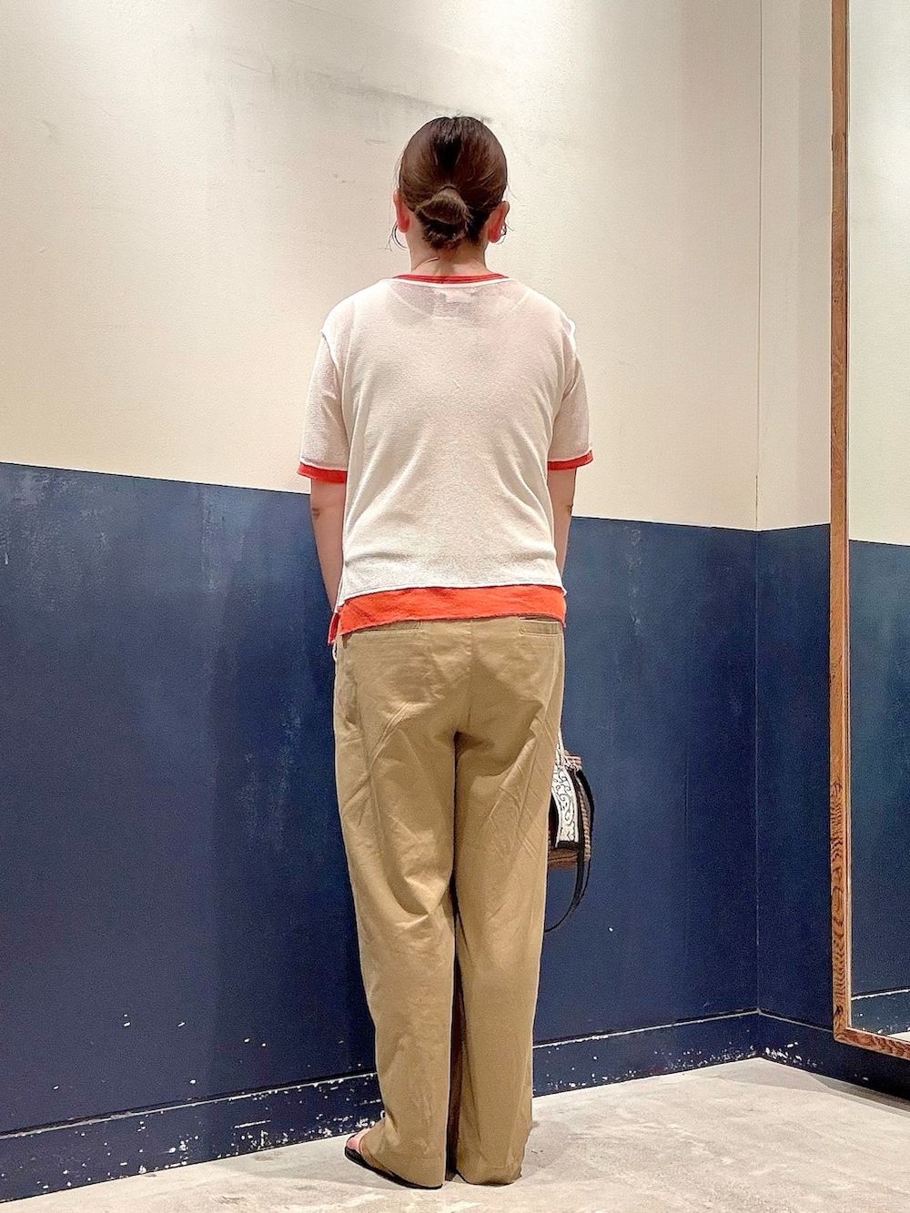 ブラウン系のトートバッグ、ベージュ系のデニムパンツ、イエロー系のサンダルを着用したレディースの夏コーディネートの3枚目の写真