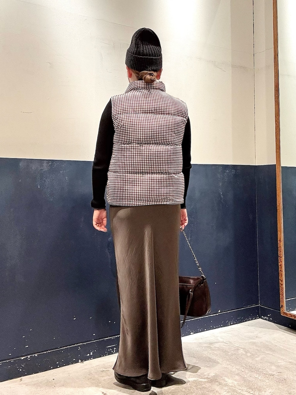 ブラウン系のショルダーバッグ、グレー系のスカート、ブラック系のニット/セーターを着用したレディースの冬コーディネートの3枚目の写真