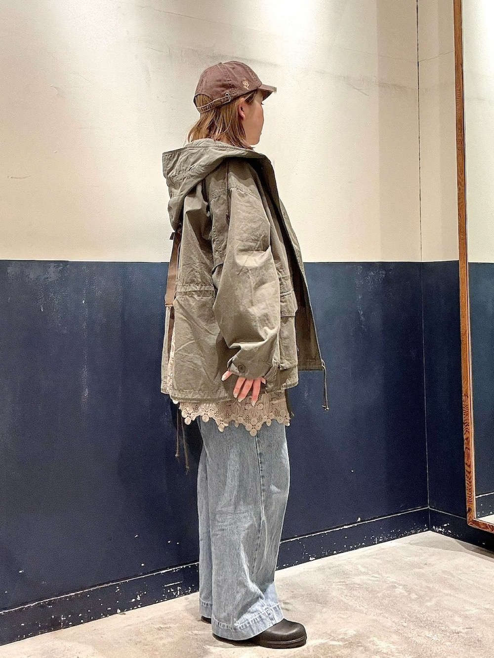 ブルー系のデニムパンツ、ホワイト系のキャミソール、イエロー系のスウェットを着用したレディースの冬コーディネートの2枚目の写真