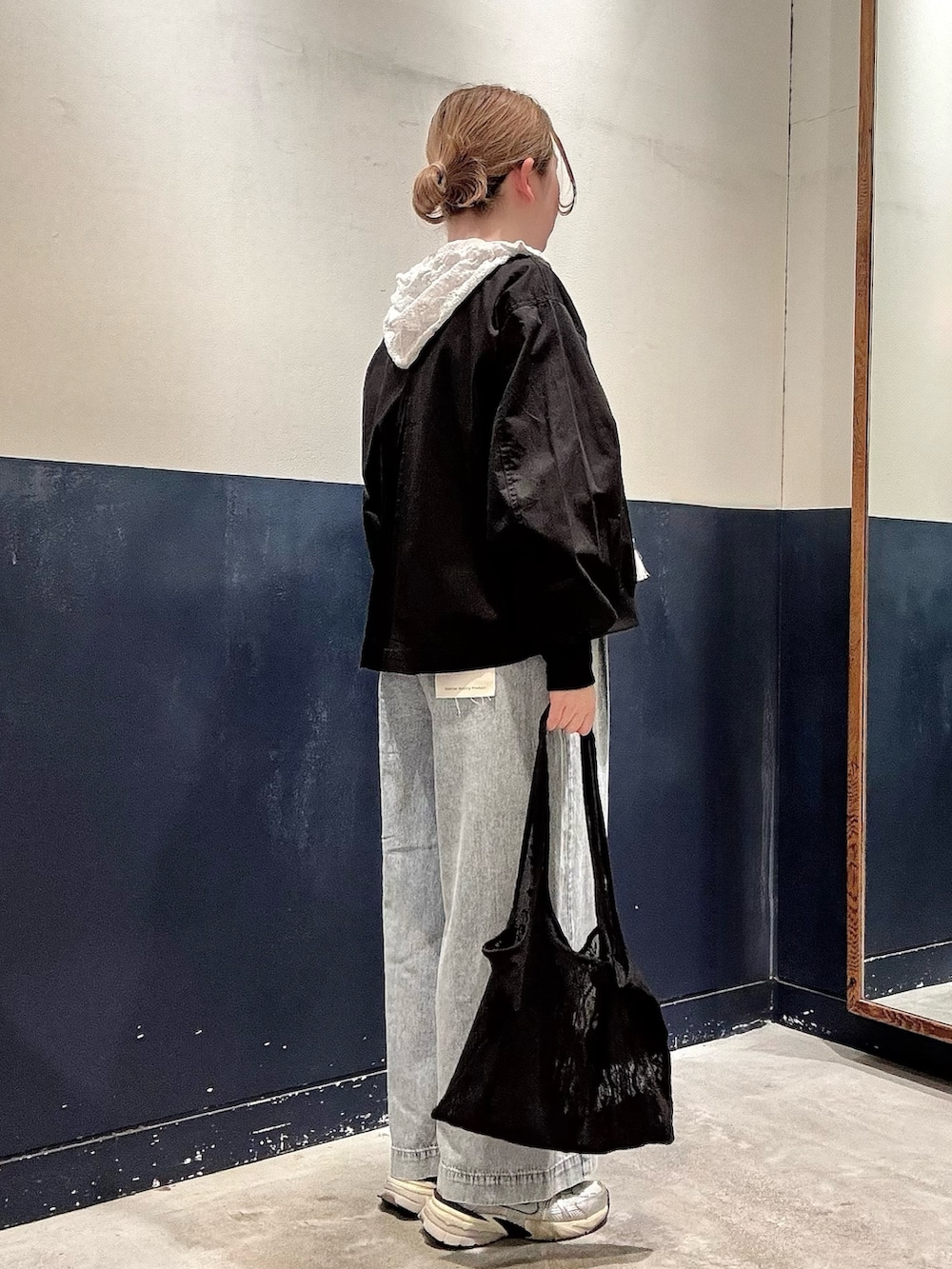 ブラック系のトートバッグ、ブルー系のデニムパンツ、ホワイト系のシャツ/ブラウスを着用したレディースの春コーディネートの2枚目の写真