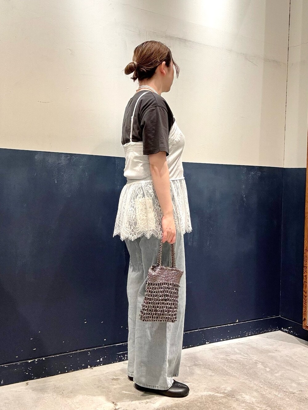 グレー系のTシャツ/カットソー、グレー系のショルダーバッグ、ブルー系のデニムパンツを着用したレディースの春コーディネートの2枚目の写真