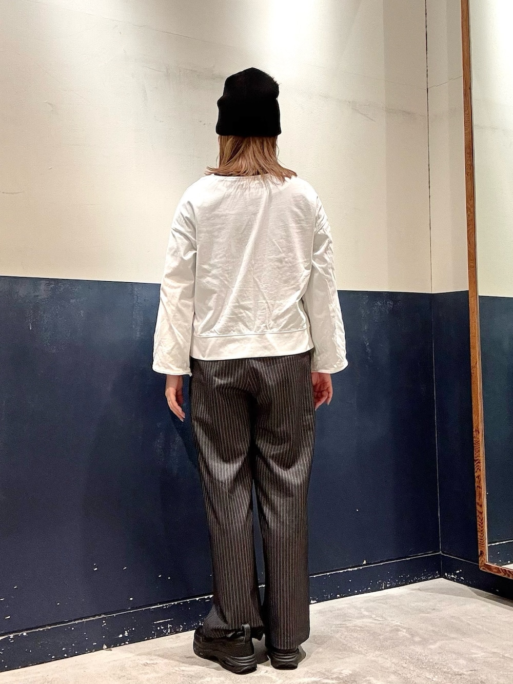 ホワイト系のTシャツ/カットソー、グレー系のスラックス、ホワイト系のネックレスを着用したレディースの春コーディネートの3枚目の写真