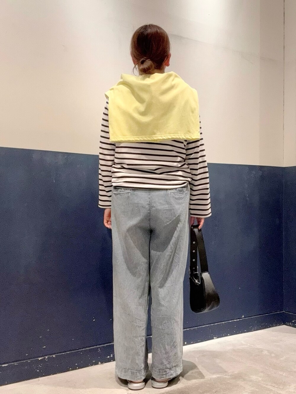 イエロー系のカーディガン/ボレロ、ブラック系のトートバッグ、ブルー系のデニムパンツを着用したレディースの夏コーディネートの3枚目の写真