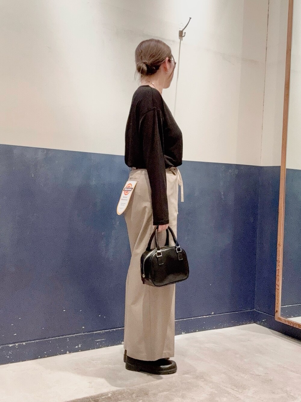 ブラック系のショルダーバッグ、ブラック系のTシャツ/カットソー、ベージュ系のその他パンツを着用したレディースの春コーディネートの2枚目の写真