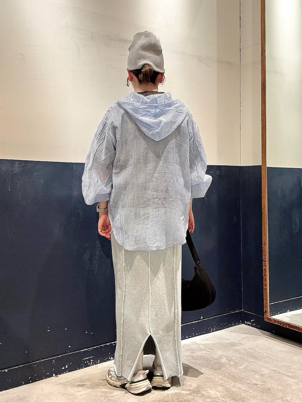 ブルー系のシャツ/ブラウス、ブラック系のショルダーバッグ、グレー系のTシャツ/カットソーを着用したレディースの春コーディネートの3枚目の写真