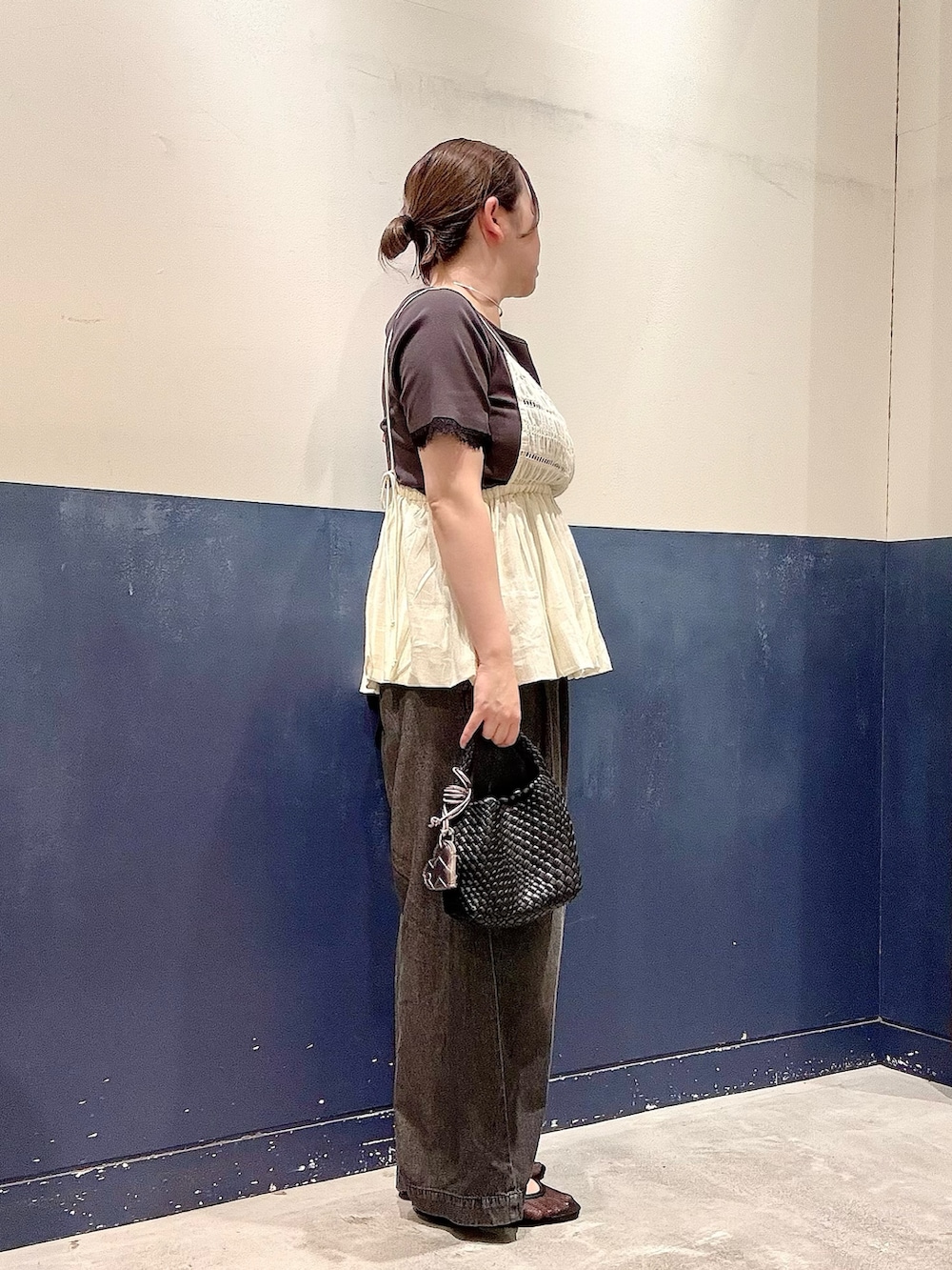 ブラック系のパンプス、ブラック系のショルダーバッグ、ブラック系のデニムパンツを着用したレディースの夏コーディネートの2枚目の写真
