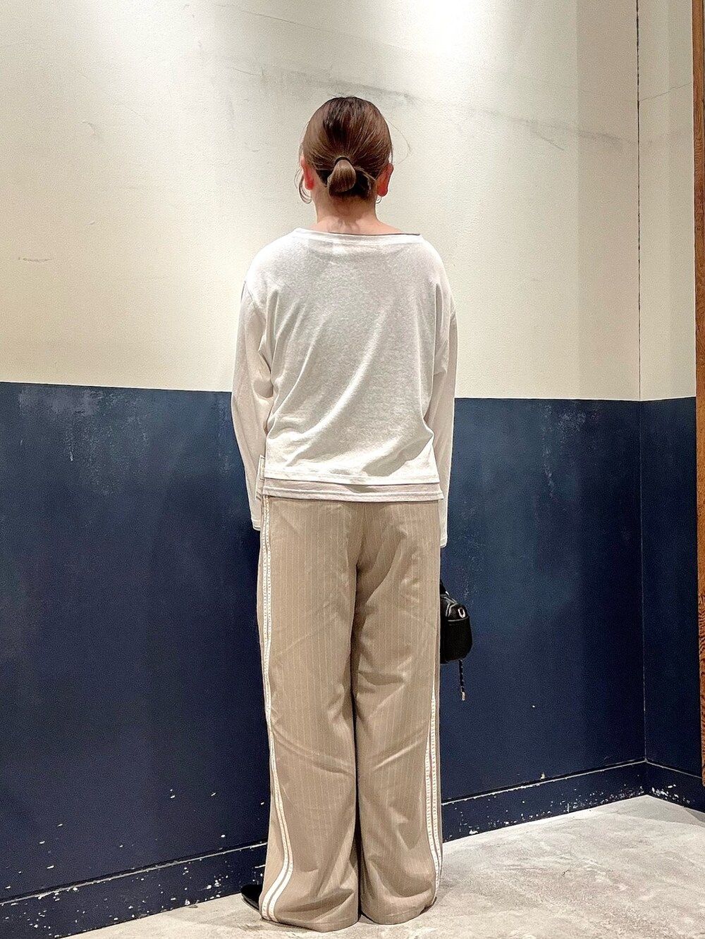 ベージュ系のスラックス、ブラック系のショルダーバッグ、ブラック系のパンプスを着用したレディースの春コーディネートの3枚目の写真