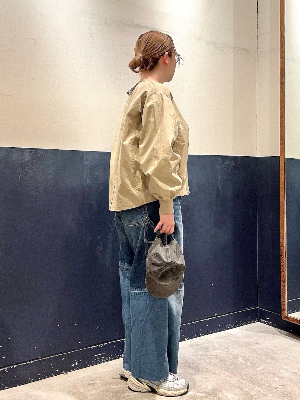 ブルー系のデニムパンツ、ベージュ系のトレンチコート、グレー系のTシャツ/カットソーを着用したレディースの春コーディネートの2枚目の写真