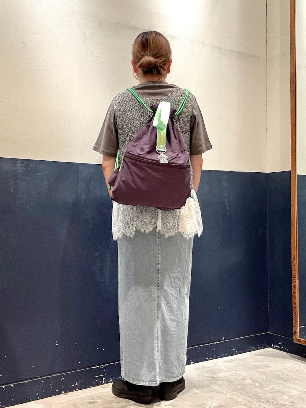 パープル系のバックパック/リュック、ブルー系のスカート、ブラック系のTシャツ/カットソーを着用したレディースの夏コーディネートの3枚目の写真