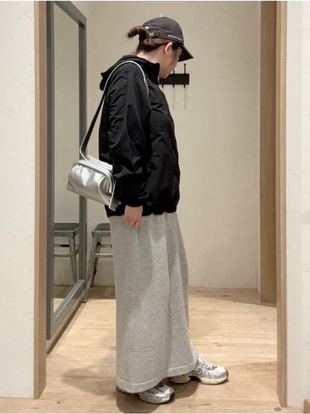 ブラック系のマウンテンパーカー、シルバー系のショルダーバッグ、ホワイト系のワンピースを着用したレディースの秋コーディネートの3枚目の写真