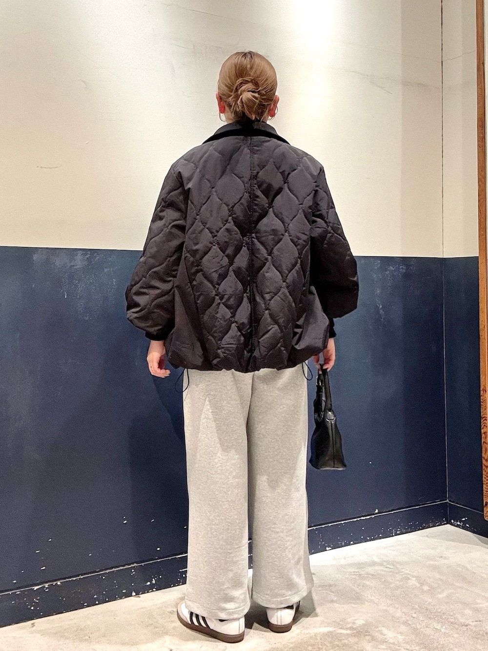 ブラック系のショルダーバッグ、グレー系のその他パンツ、ブラック系のブルゾンを着用したレディースの冬コーディネートの3枚目の写真