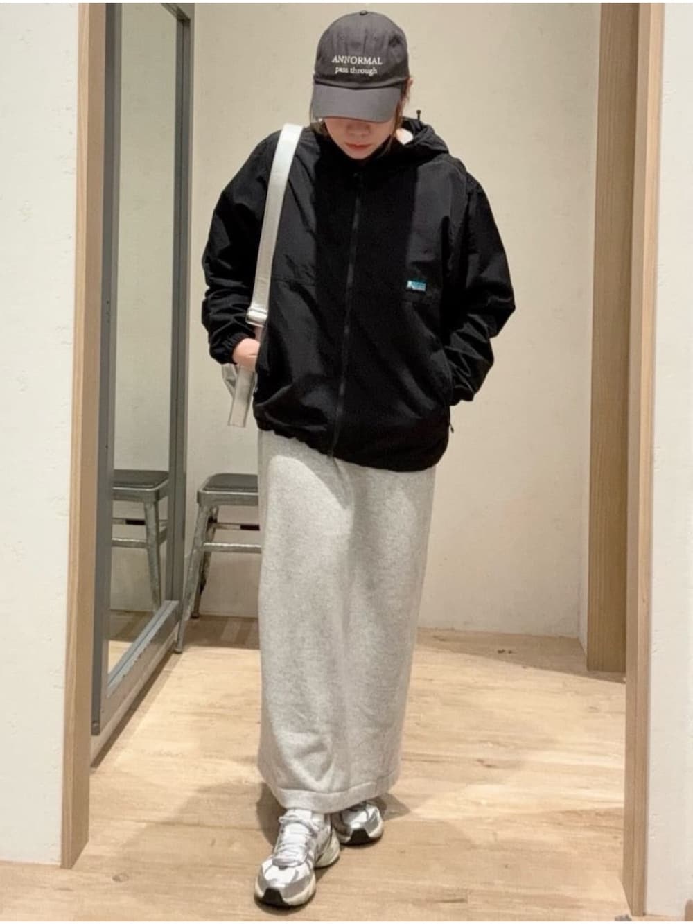 ブラック系のマウンテンパーカー、シルバー系のショルダーバッグ、ホワイト系のワンピースを着用したレディースの秋コーディネートの2枚目の写真