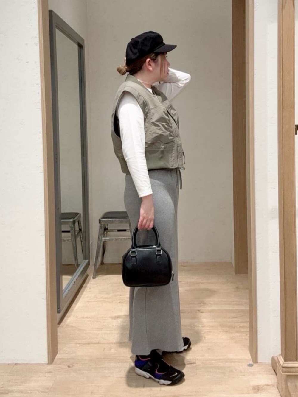 グレー系のスカート、ブラック系のショルダーバッグ、ホワイト系のTシャツ/カットソーを着用したレディースの春コーディネートの2枚目の写真