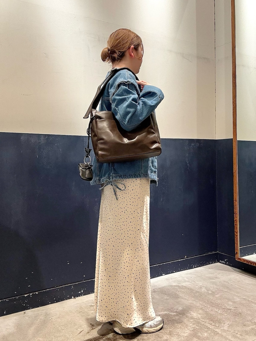 ホワイト系のスカート、ブルー系のデニムジャケット、ベージュ系のTシャツ/カットソーを着用したレディースの春コーディネートの2枚目の写真