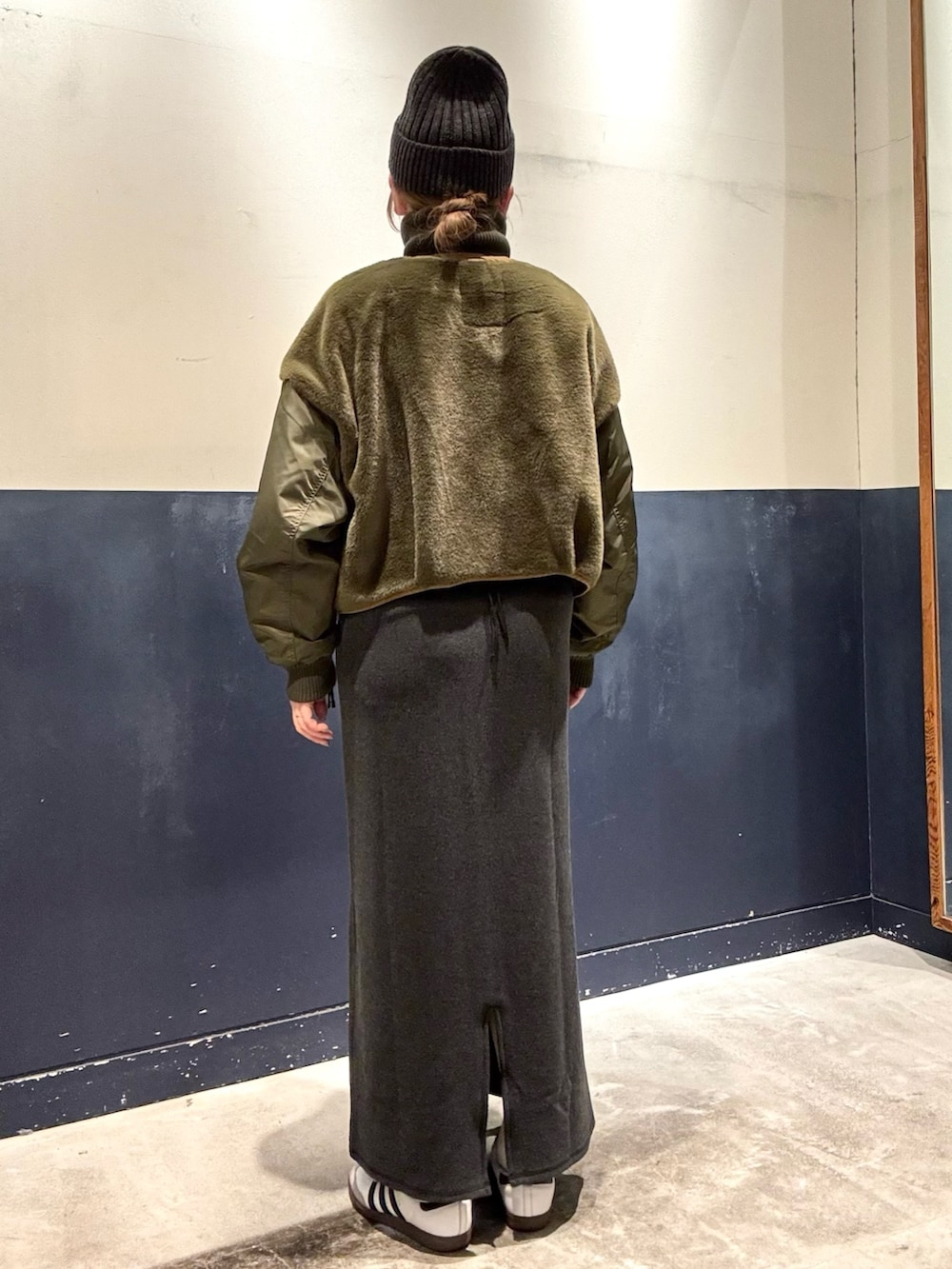 グリーン系のミリタリージャケット、グレー系のワンピースを着用したレディースの冬コーディネートの3枚目の写真