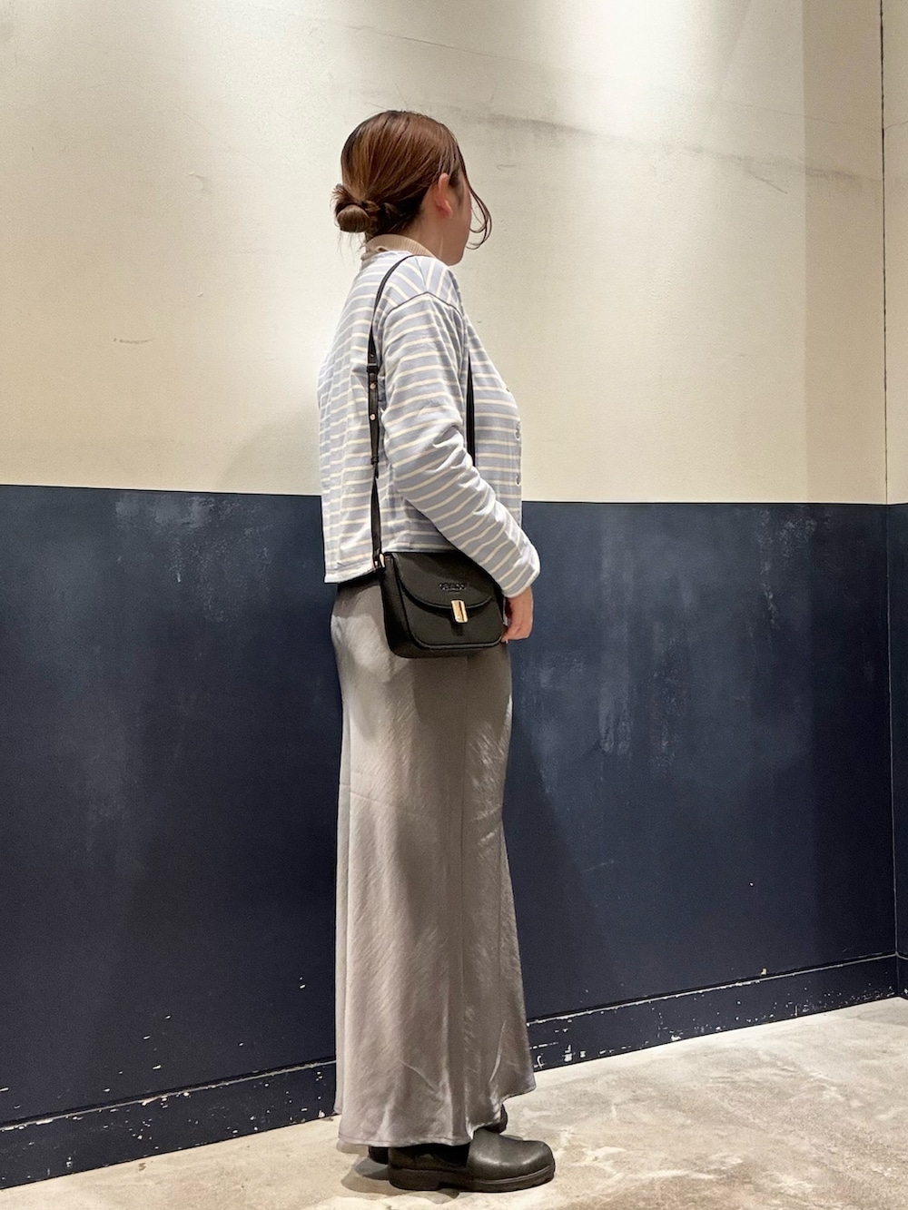 ブラック系のショルダーバッグ、ブルー系のカーディガン/ボレロ、ホワイト系のニット/セーターを着用したレディースの冬コーディネートの2枚目の写真