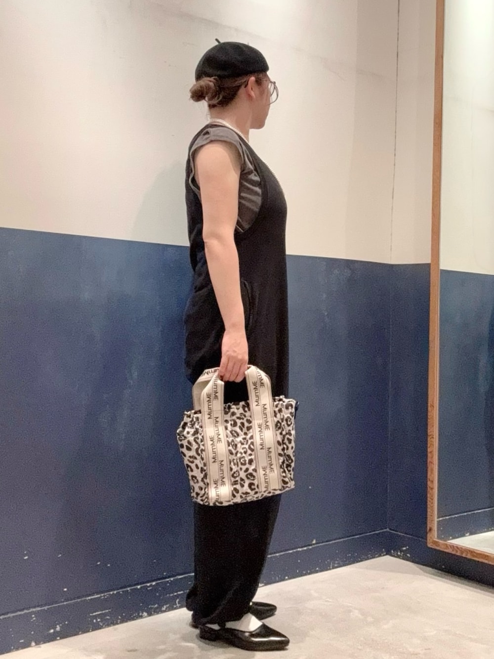 ブラック系のサロペット/オーバーオール、グレー系のTシャツ/カットソー、ホワイト系のショルダーバッグを着用したレディースの秋コーディネートの2枚目の写真