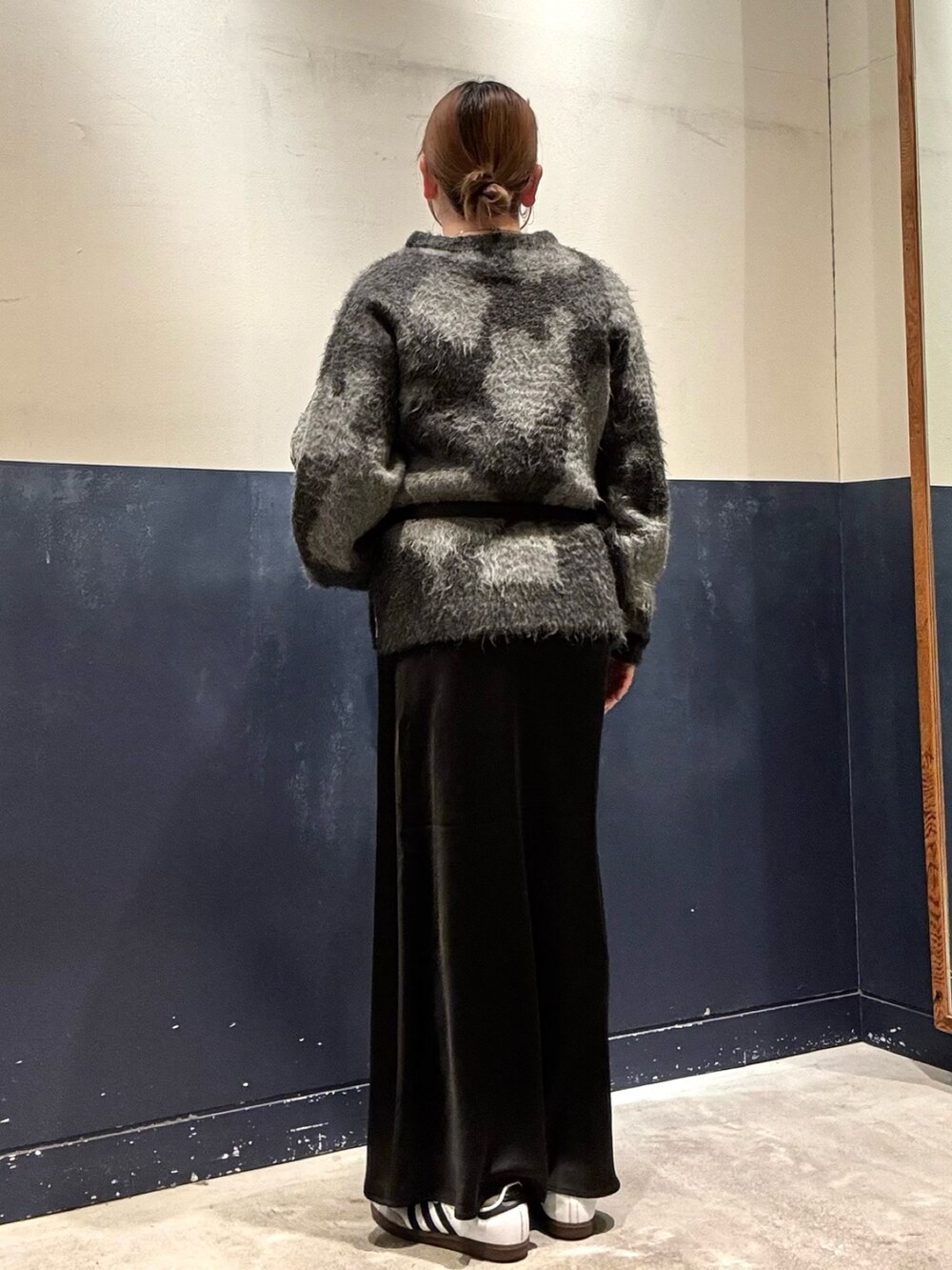 ブラック系のスカート、ブラック系のボディバッグ/ウエストポーチ、グレー系のニット/セーターを着用したレディースの冬コーディネートの3枚目の写真