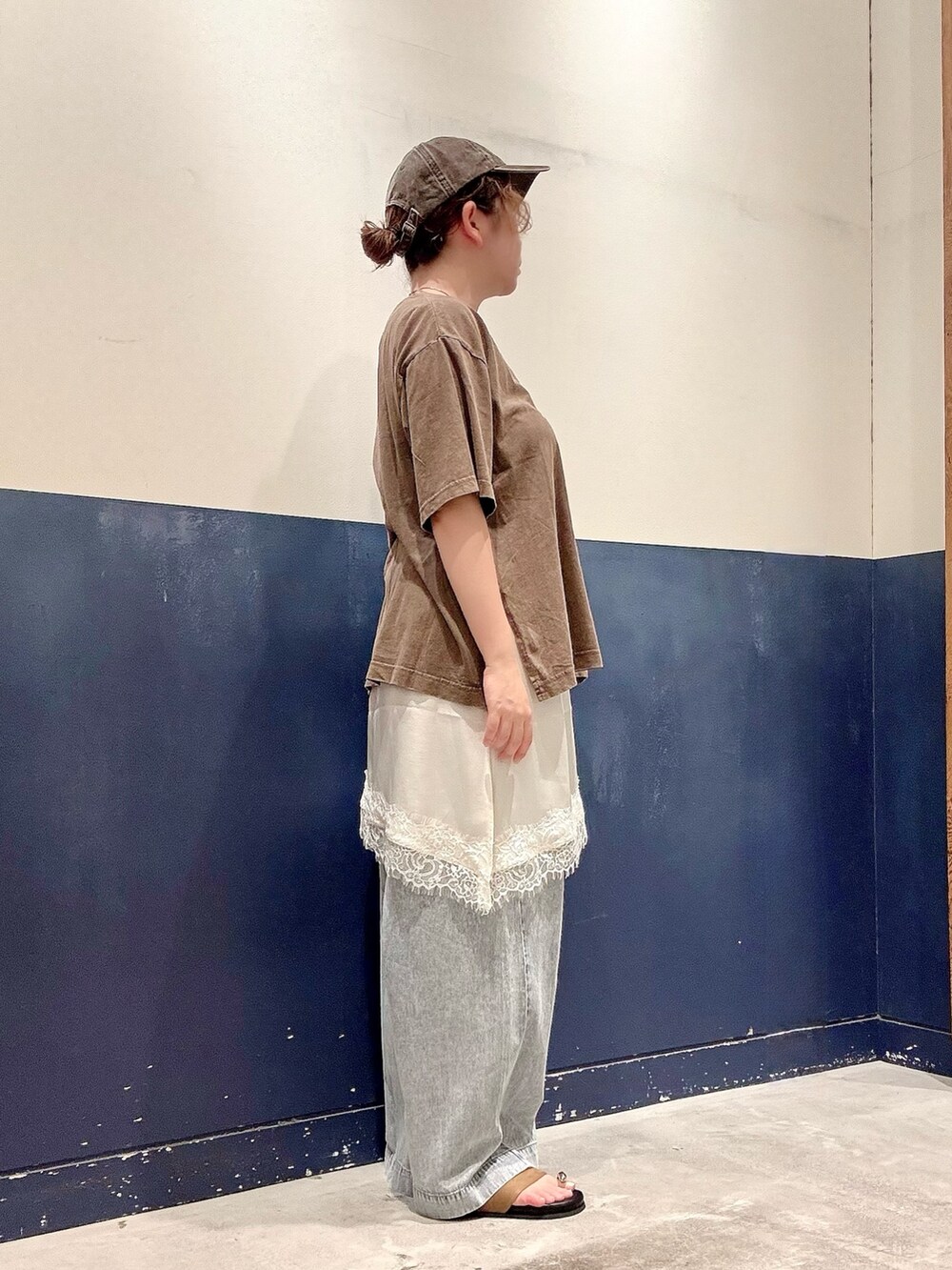 ブラウン系のTシャツ/カットソー、ホワイト系のスカート、ブルー系のデニムパンツを着用したレディースの夏コーディネートの2枚目の写真