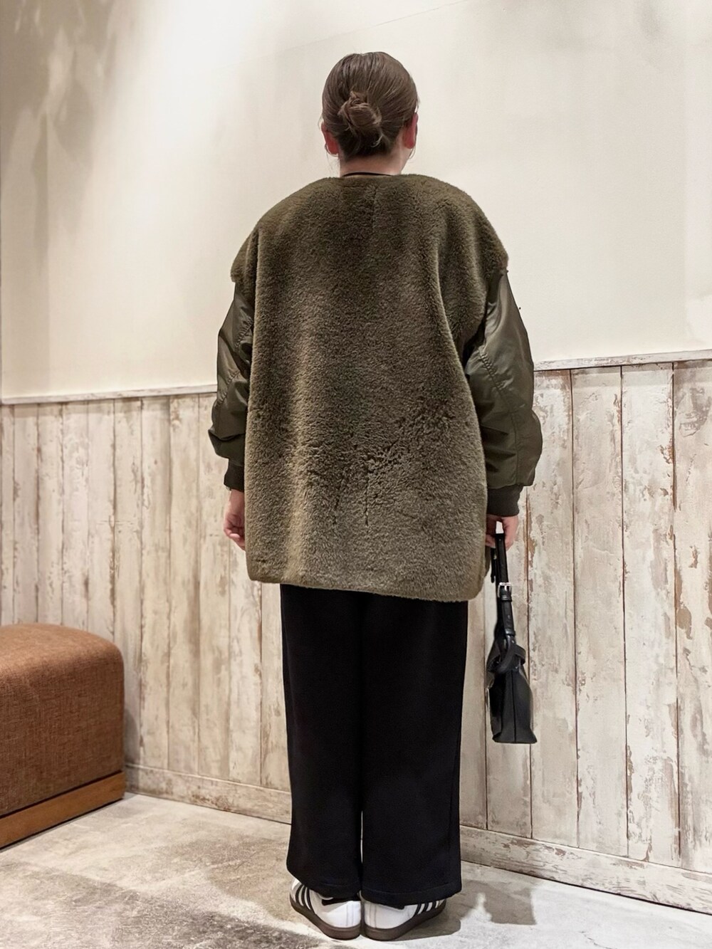 グリーン系のブルゾン、グレー系のスウェット、ブラック系のショルダーバッグを着用したレディースの冬コーディネートの3枚目の写真