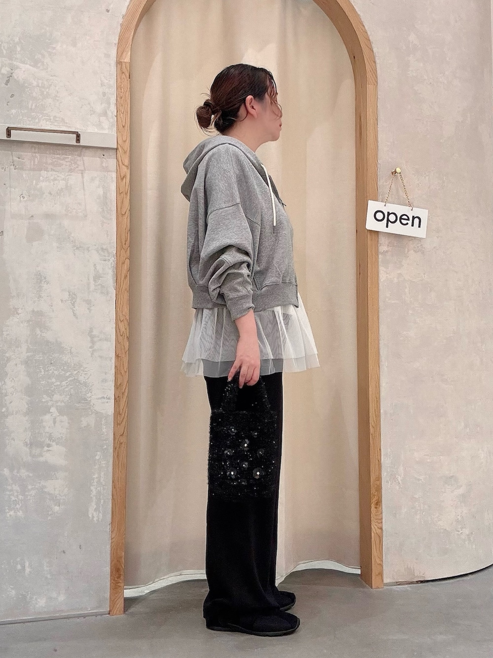 グレー系のパーカー、ブラック系のショルダーバッグ、ブラック系のその他パンツを着用したレディースの秋コーディネートの2枚目の写真