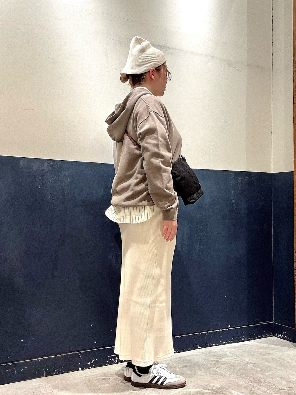 イエロー系のシャツ/ブラウス、ベージュ系のパーカー、ブラック系のショルダーバッグを着用したレディースの冬コーディネートの2枚目の写真