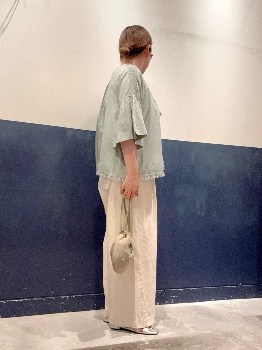 シルバー系のサンダル、グリーン系のハンドバッグ、グレー系のタンクトップを着用したレディースの夏コーディネートの2枚目の写真