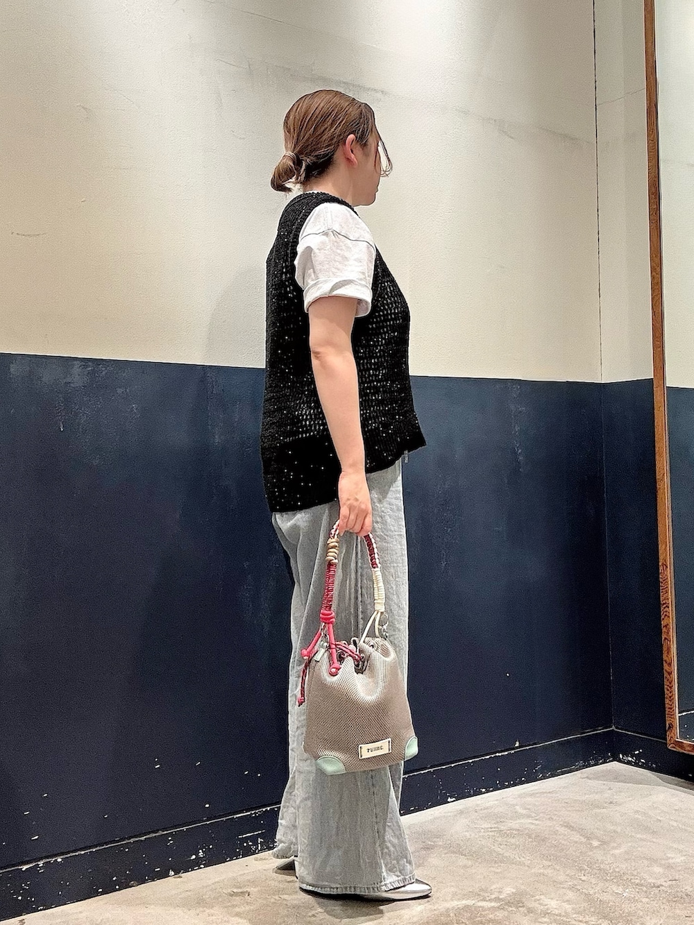 グレー系のショルダーバッグ、ブルー系のデニムパンツ、グレー系のTシャツ/カットソーを着用したレディースの夏コーディネートの2枚目の写真