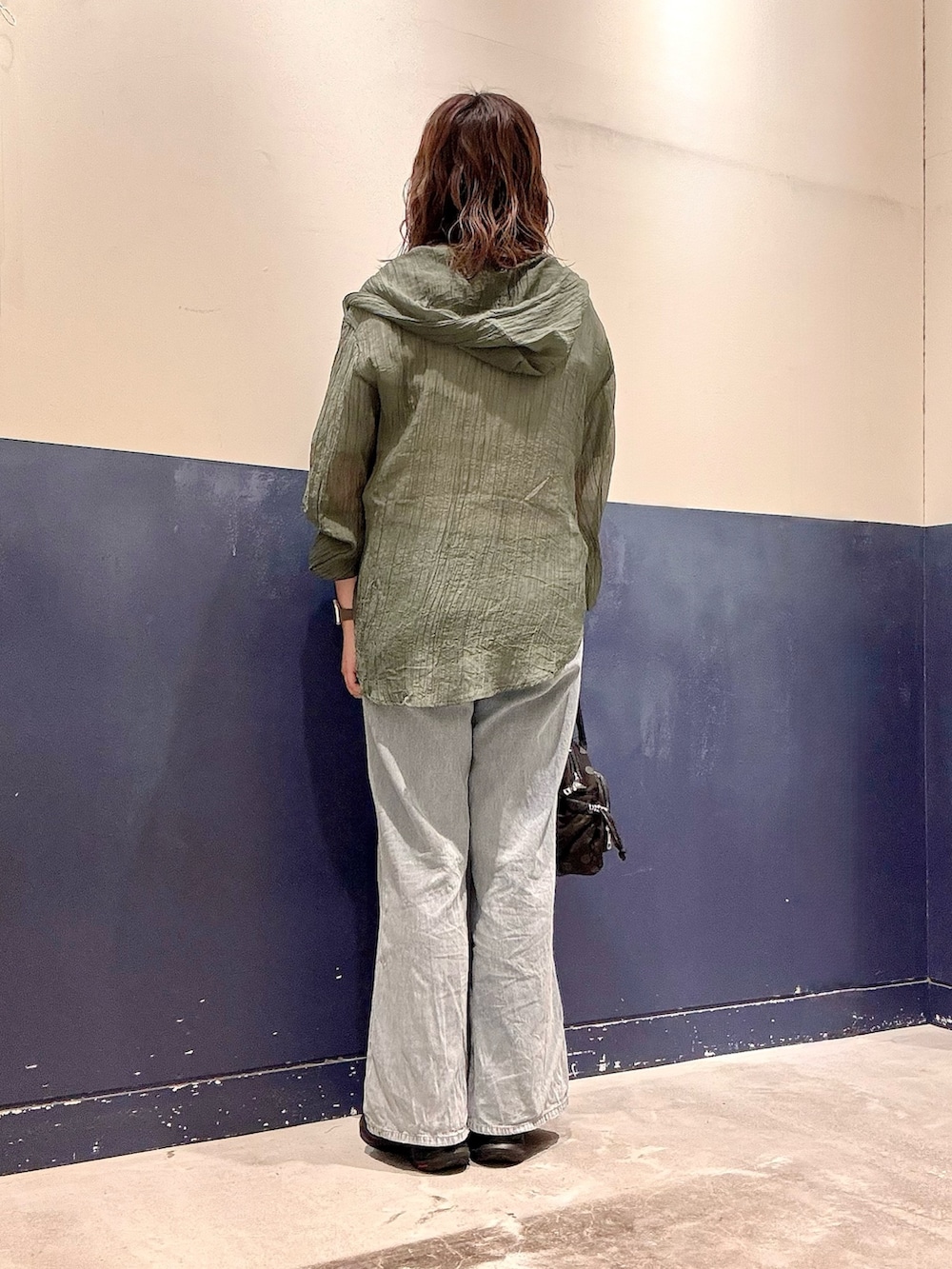 ブルー系のデニムパンツ、ブラック系のショルダーバッグ、グリーン系のシャツ/ブラウスを着用したレディースの夏コーディネートの3枚目の写真