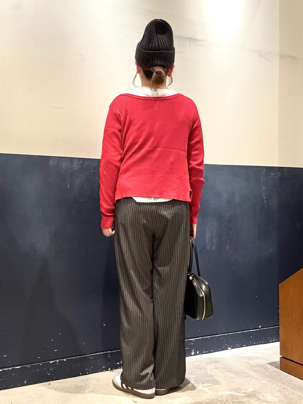 ホワイト系のTシャツ/カットソー、レッド系のカーディガン/ボレロ、グレー系のスラックスを着用したレディースの冬コーディネートの3枚目の写真