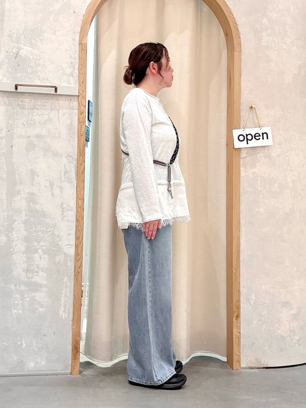 ブルー系のデニムパンツ、ホワイト系のTシャツ/カットソー、ブラック系のスマホグッズを着用したレディースの夏コーディネートの2枚目の写真