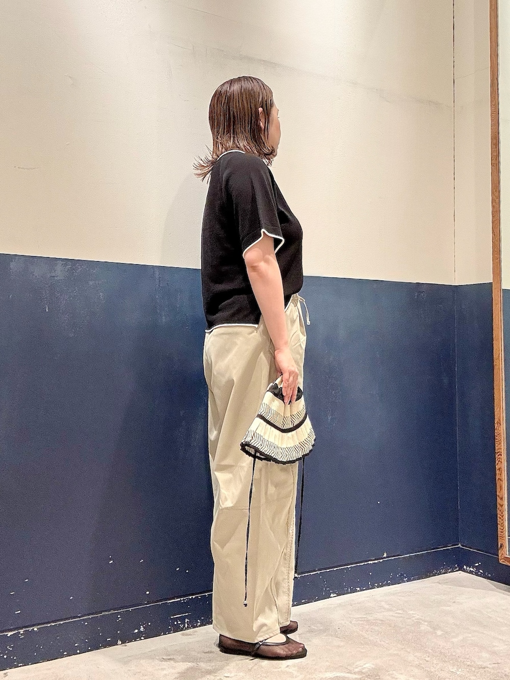 ブラック系のパンプス、ブラック系のニット/セーター、グリーン系のその他パンツを着用したレディースの夏コーディネートの2枚目の写真