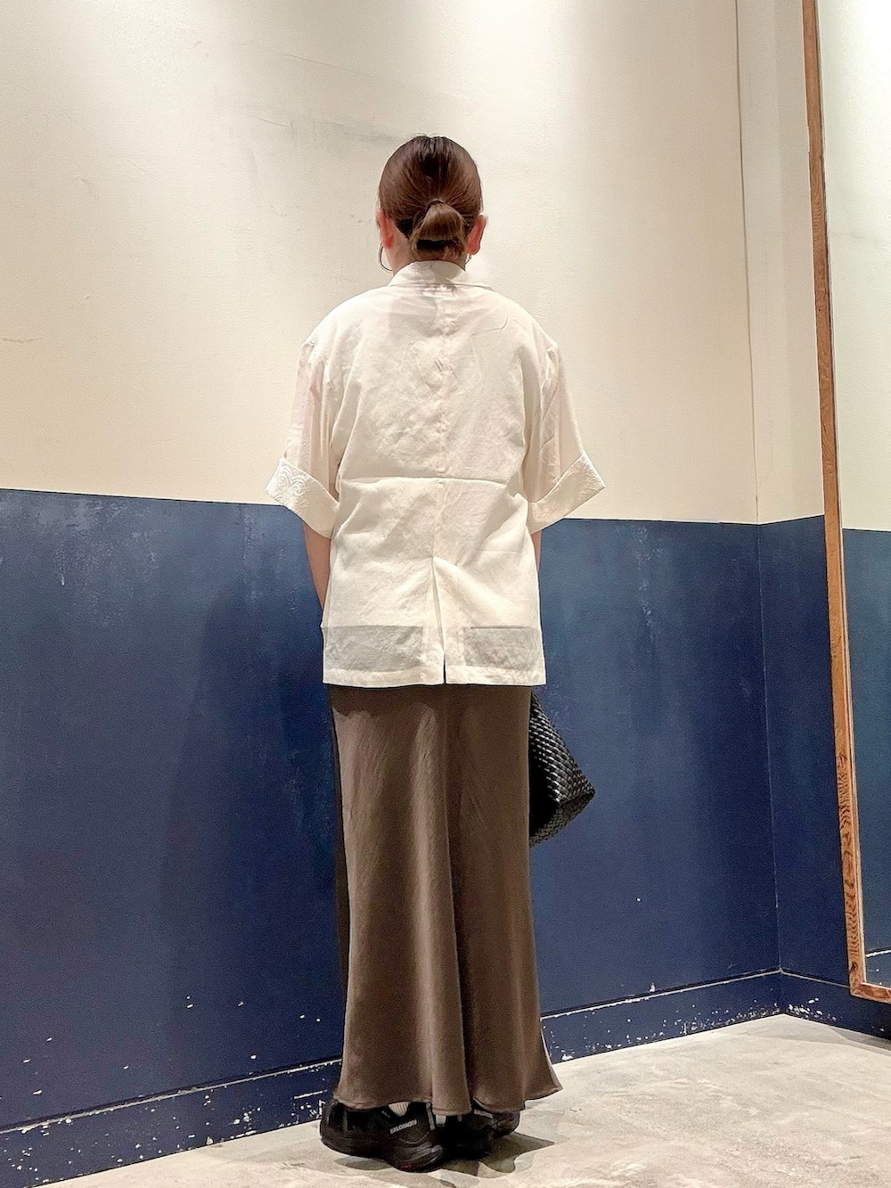 ブラック系のショルダーバッグ、グレー系のスカート、ホワイト系のTシャツ/カットソーを着用したレディースの夏コーディネートの3枚目の写真