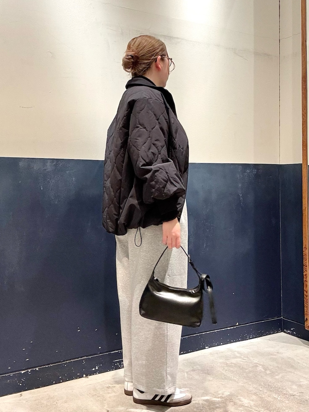 ブラック系のショルダーバッグ、グレー系のその他パンツ、ブラック系のブルゾンを着用したレディースの冬コーディネートの2枚目の写真