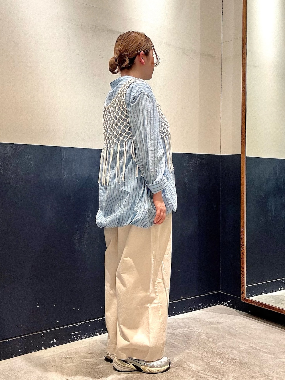 ホワイト系のデニムパンツ、ホワイト系のベスト、ブルー系のシャツ/ブラウスを着用したレディースの春コーディネートの2枚目の写真