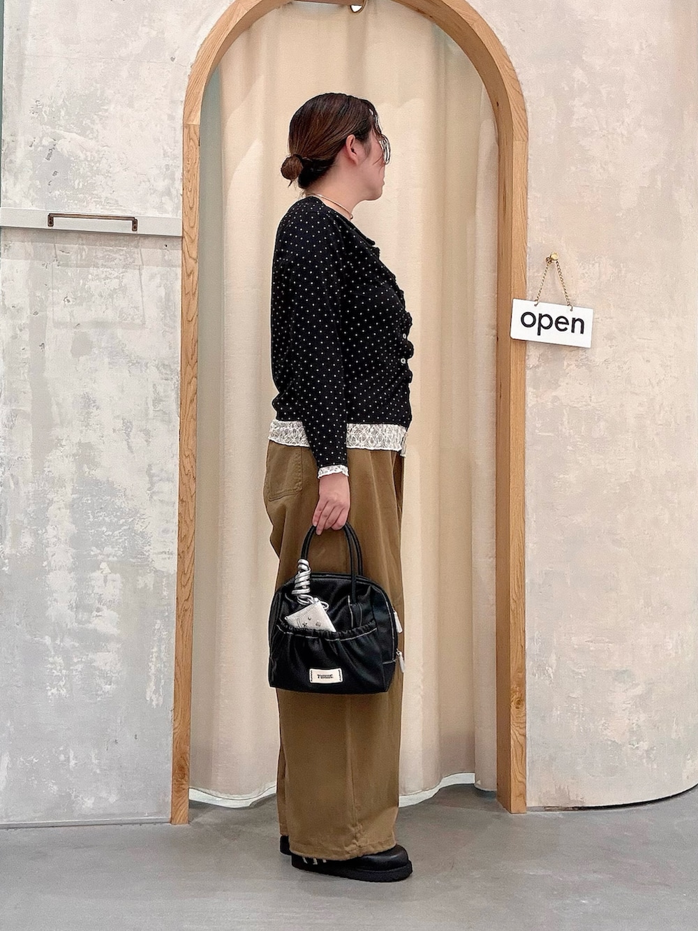 ブラック系のショルダーバッグ、ベージュ系のその他パンツ、ブラック系のカーディガン/ボレロを着用したレディースの秋コーディネートの2枚目の写真