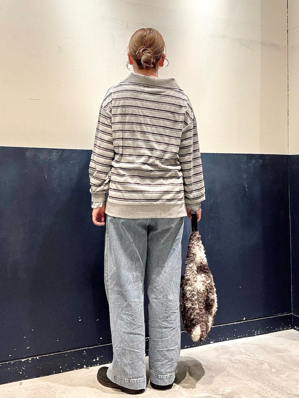 グレー系のトートバッグ、ブルー系のTシャツ/カットソー、ブルー系のデニムパンツを着用したレディースの冬コーディネートの3枚目の写真