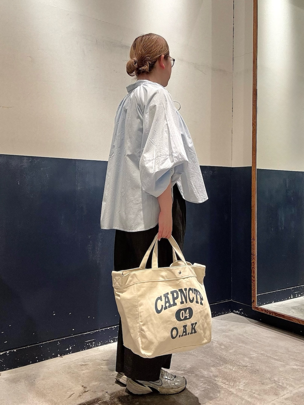 ブラック系のデニムパンツ、ホワイト系のショルダーバッグ、ブルー系のシャツ/ブラウスを着用したレディースの春コーディネートの2枚目の写真