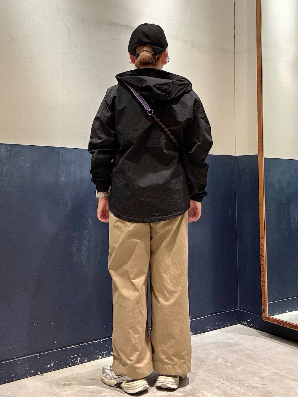 グレー系のTシャツ/カットソー、ブラック系のマウンテンパーカー、ベージュ系のデニムパンツを着用したレディースの春コーディネートの3枚目の写真