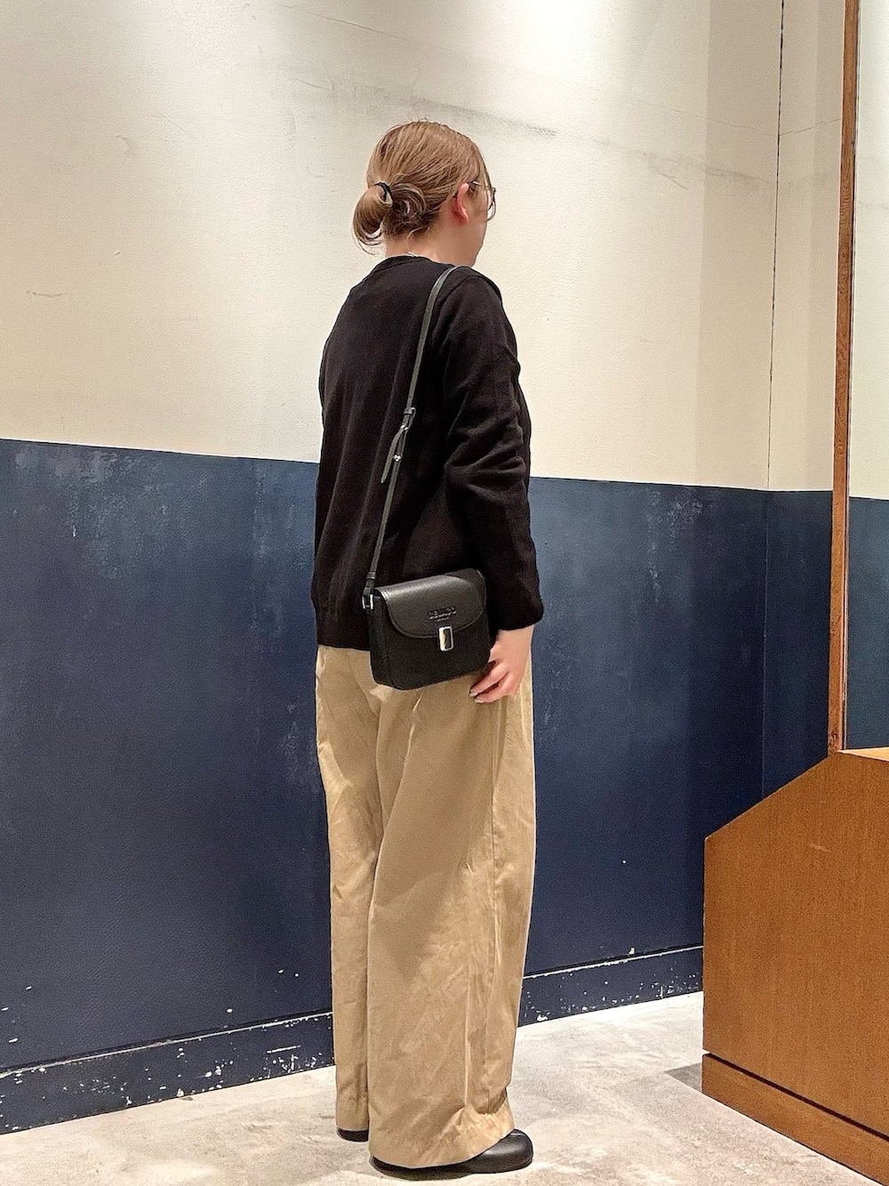 ホワイト系のTシャツ/カットソー、ブラック系のショルダーバッグ、ベージュ系のデニムパンツを着用したレディースの冬コーディネートの2枚目の写真